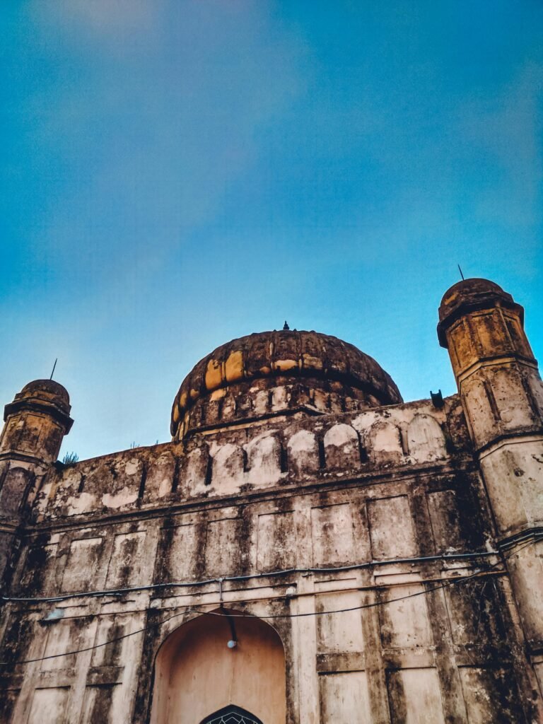 A striking view of the historical mosque facade under a clear blue sky in Dhaka, Bangladesh.