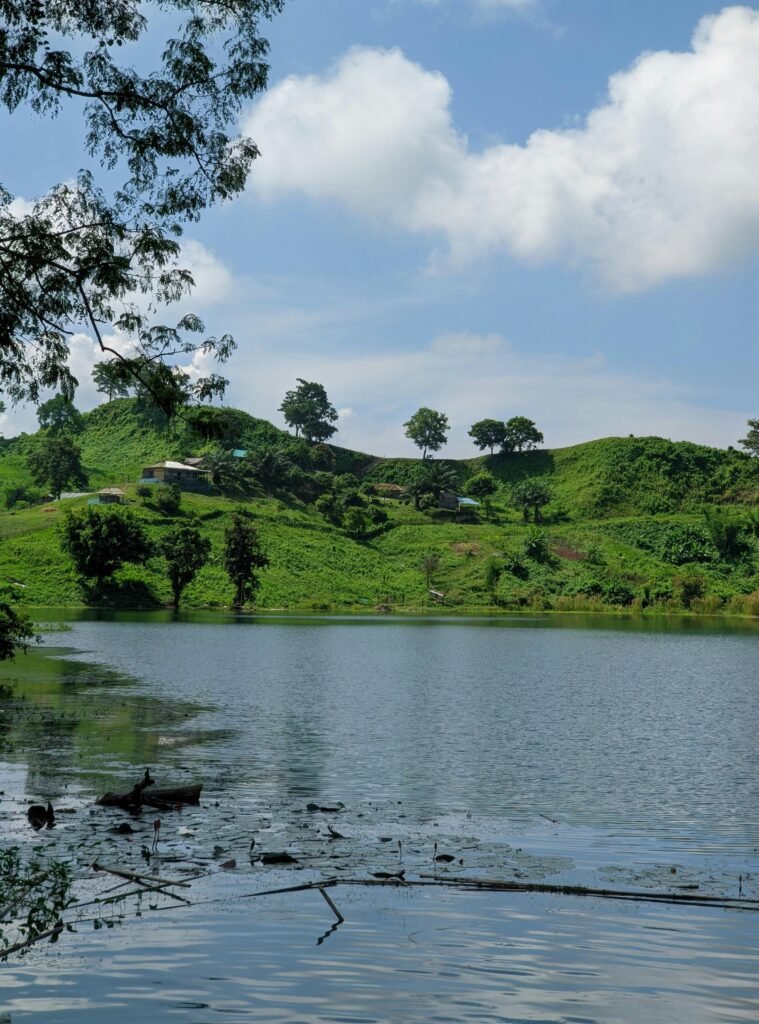 Peaceful view of hills and pond in Bandarban, Bangladesh under a clear blue sky.