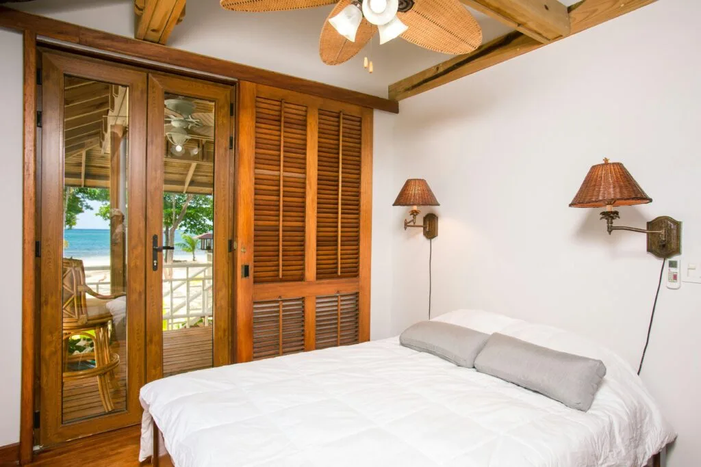 A serene beachfront bedroom with modern design and lake view.