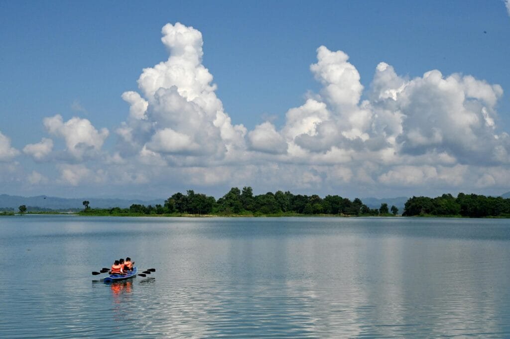 Explore the serene beauty of kayaking on Kaptai Lake in Bangladesh under a vibrant blue sky.