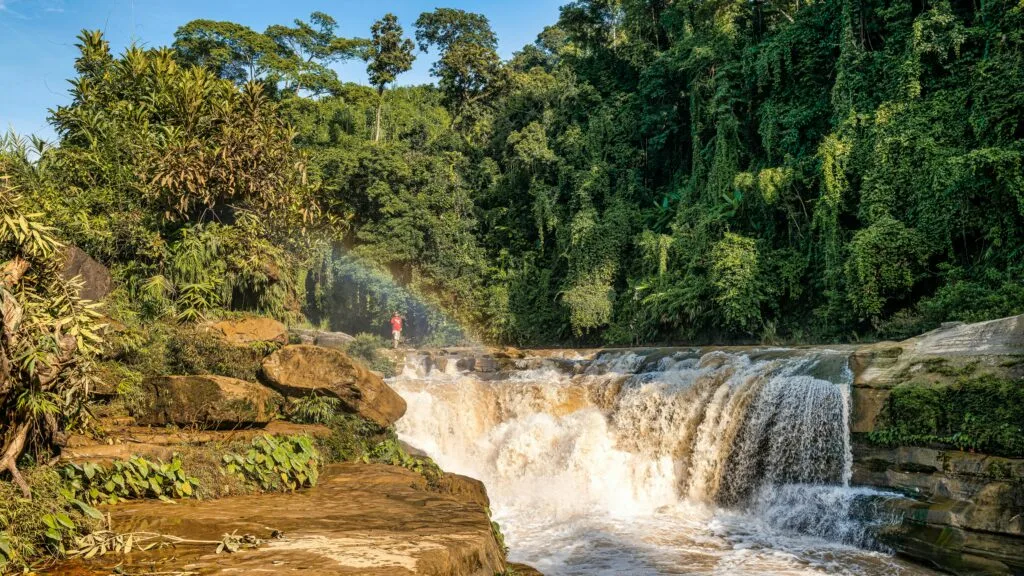 A breathtaking view of Nafa-Khum waterfall surrounded by lush green forest in Bandarban, Bangladesh.